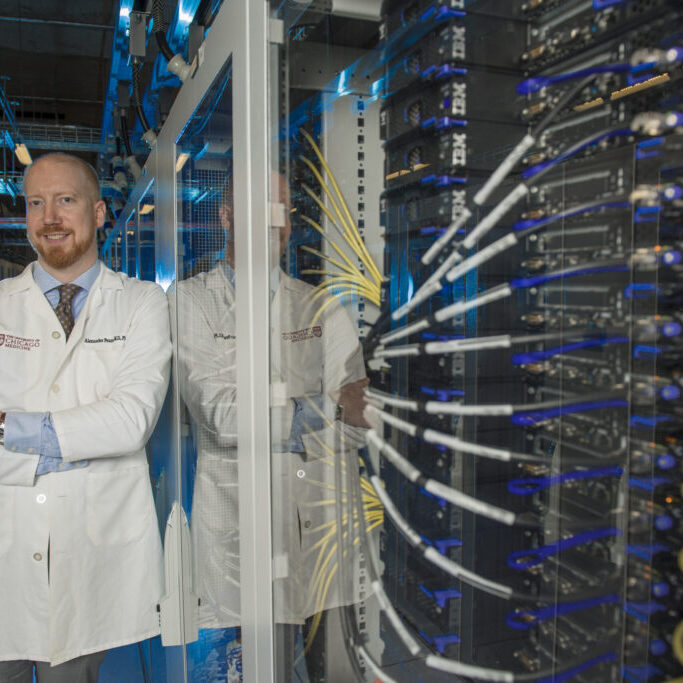 Alexander T Pearson, MD PhD, Associate Professor of Medicine at the University of Chicago, Director of Data Sciences and Director of Head/Neck Cancer in the Section of Hematology/Oncology. Dr. Pearson is a leading voice in applying quantitative methods to cancer research poses for a portrait with computer servers in Chicago on Tuesday, Aug. 27, 2024. Photo by Mark Black